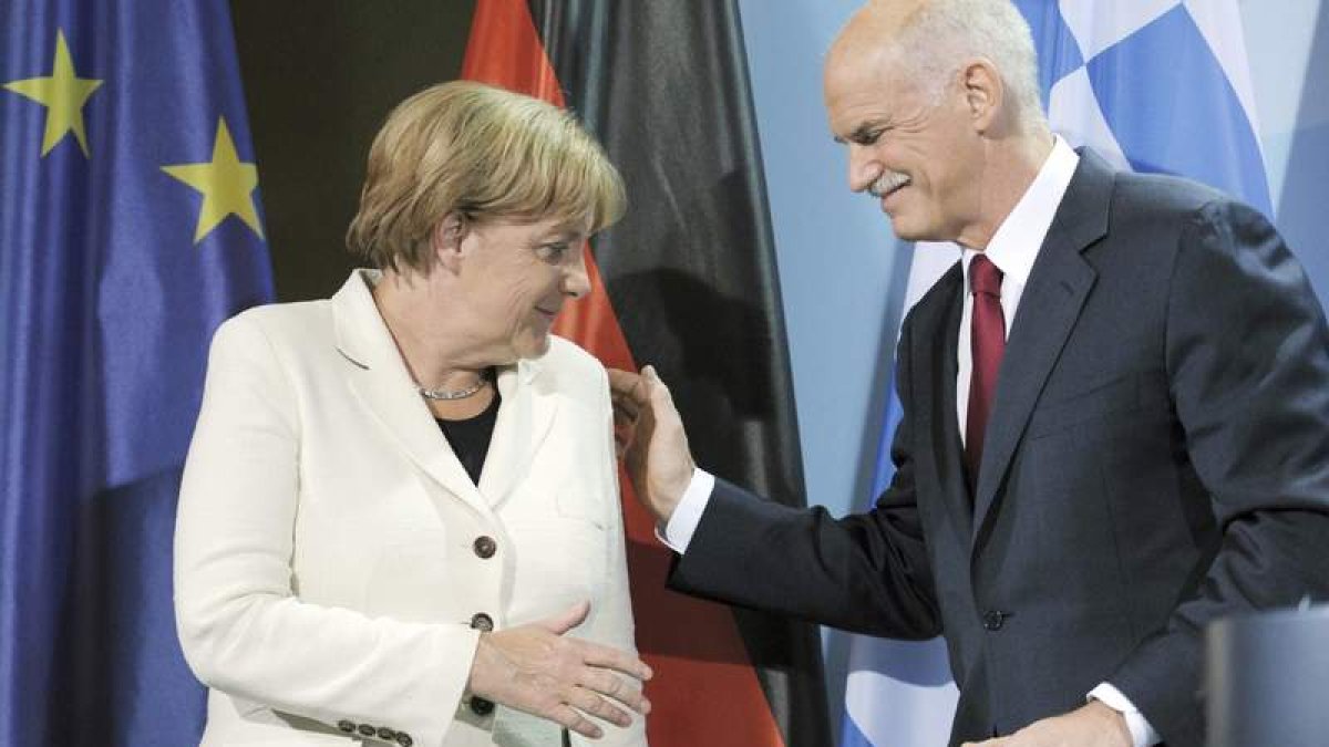 Angela Merkel saluda al primer ministro griego George Papandreu, ayer en Berlín.