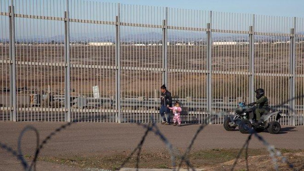 Una mujer migrante es detenida por la policia estadounidense.