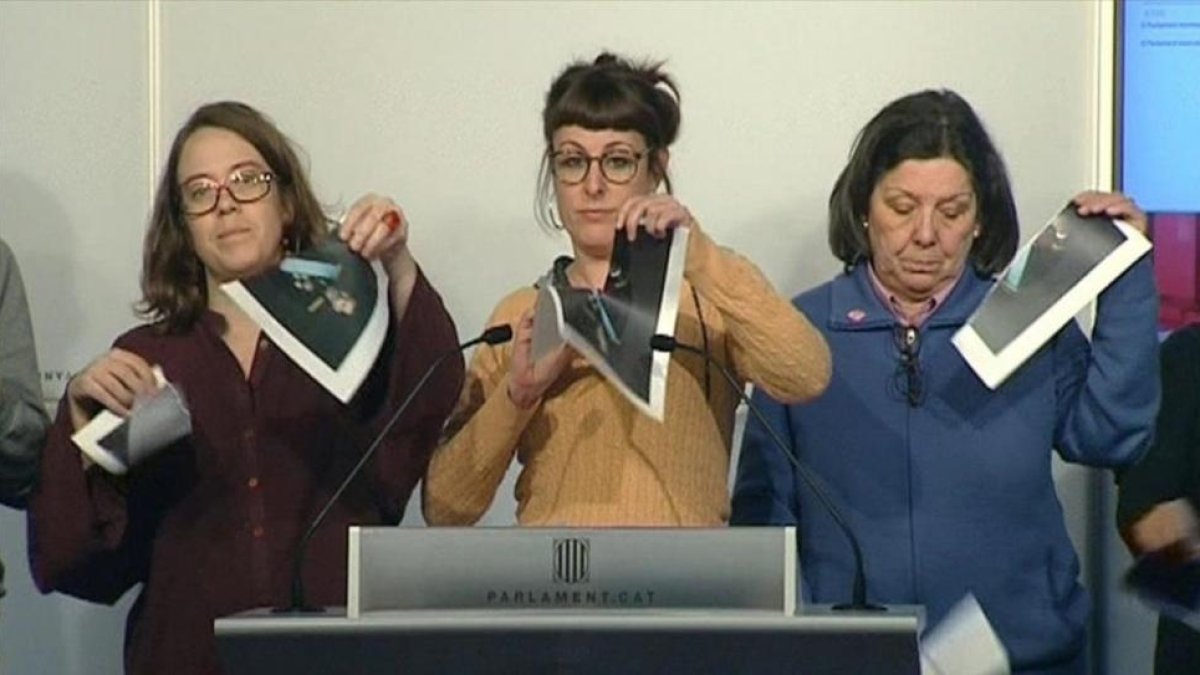 Las diputadas de la CUP Eulàlia Reguant, Mireia Vehí y Gabriela Serra rompen fotos del Rey en una rueda de prensa en el Parlament, el pasado día 12 de diciembre.