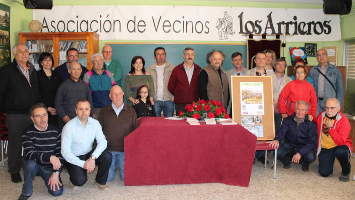 Organización y vecinos posan junto al cartel ganador y al del segundo clasificado, Ramón Celada.