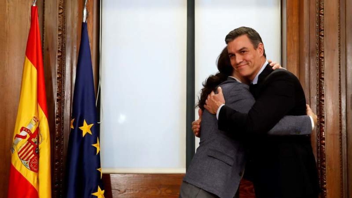 El candidato a la investidura, Pedro Sánchez, y el líder de Podemos, Pablo Iglesias, se abrazan tras el acto de firma del acuerdo de coalición.
