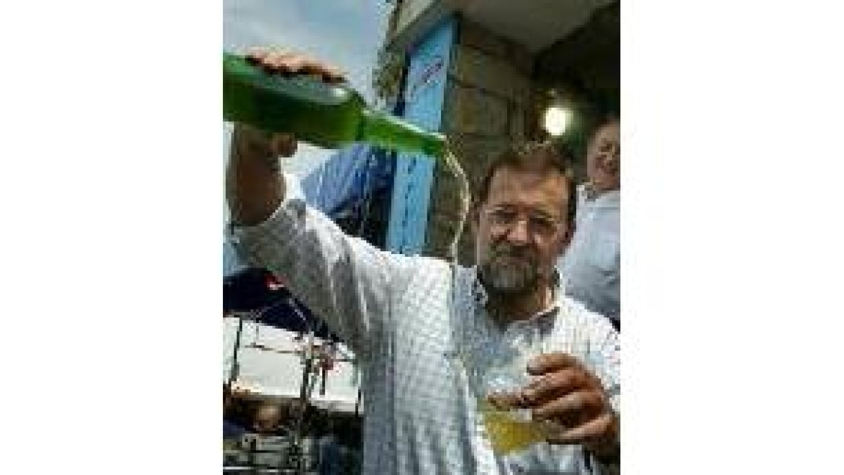Rajoy escancia sidra durante la fiesta anual del PP en Villayón