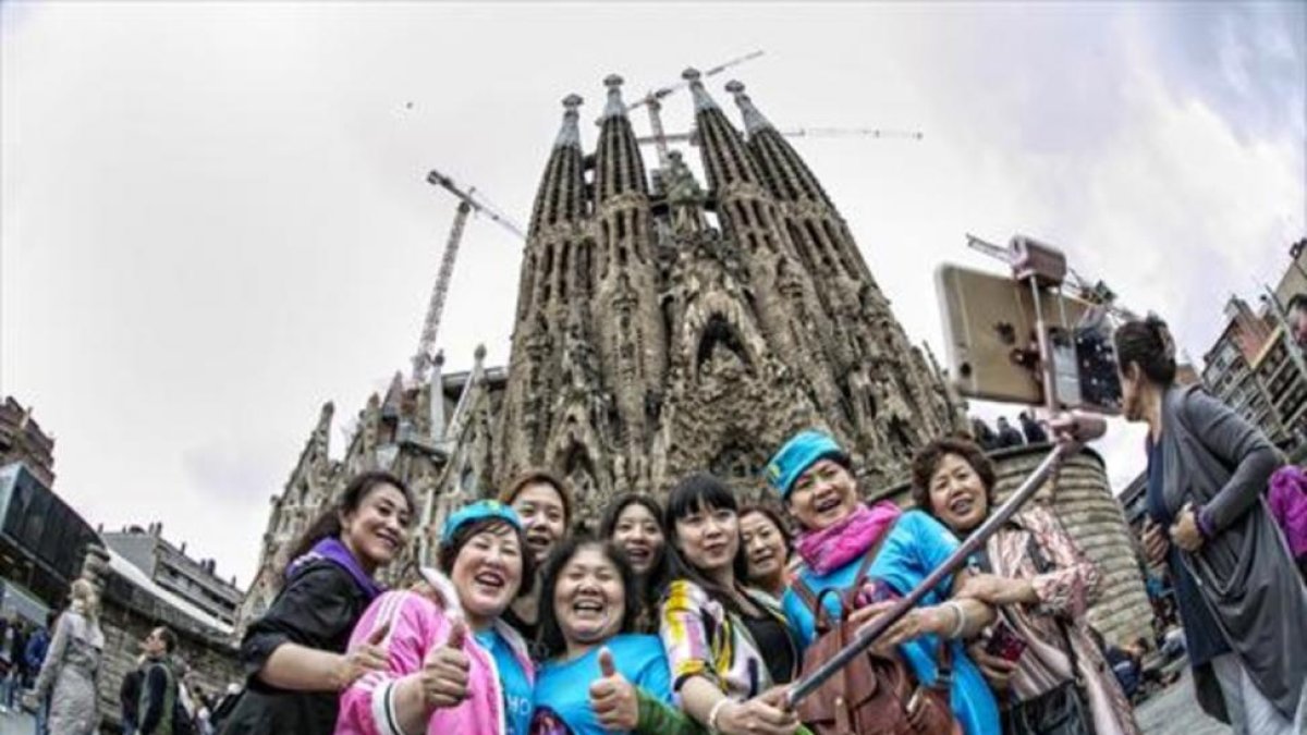 Turistas chinos se fotografían ante la Sagrada Familia, en Barcelona