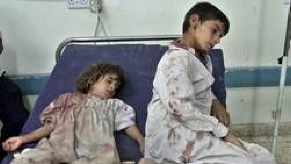 Dos niños heridos esperan atención sanitaria en un hospital de Faluya tras los bombardeos