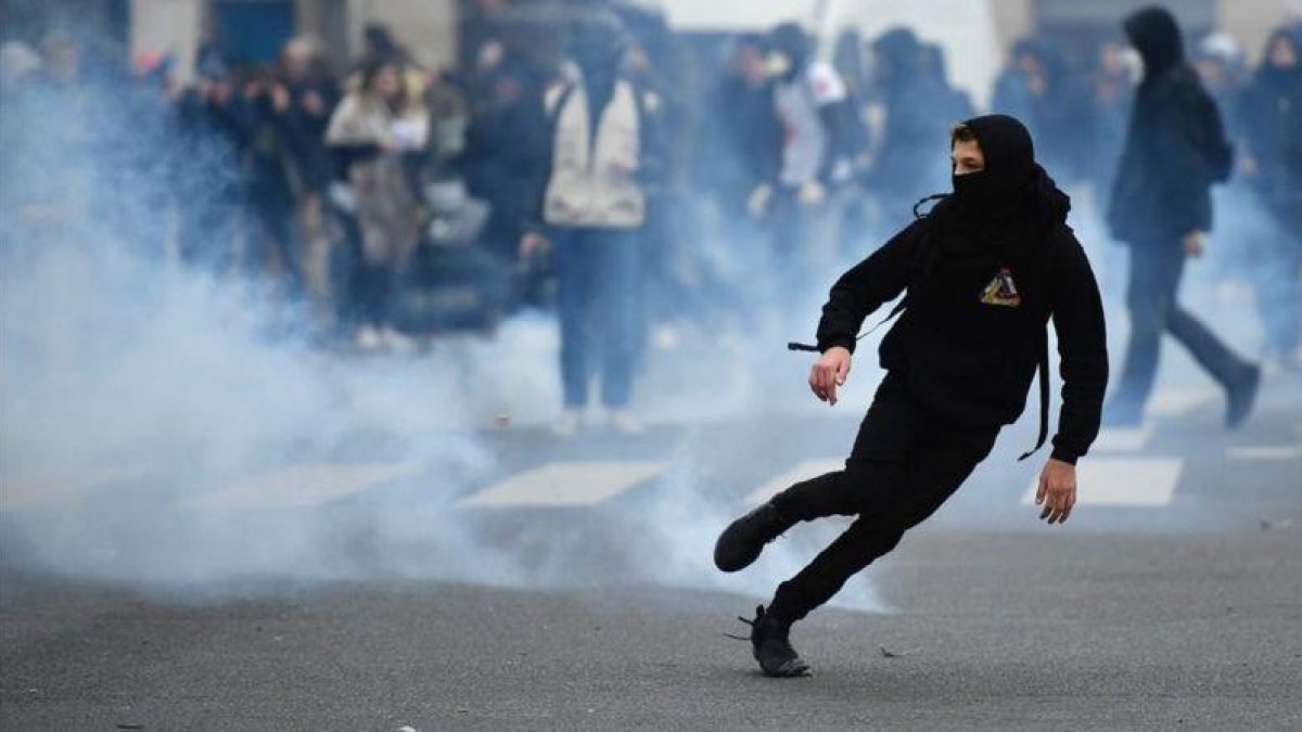 Un manifestante huye de los gases disparados por la policía.