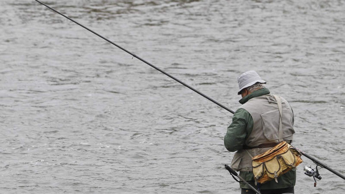 Un pescador intenta capturar alguna trucha en el río Órbigo.