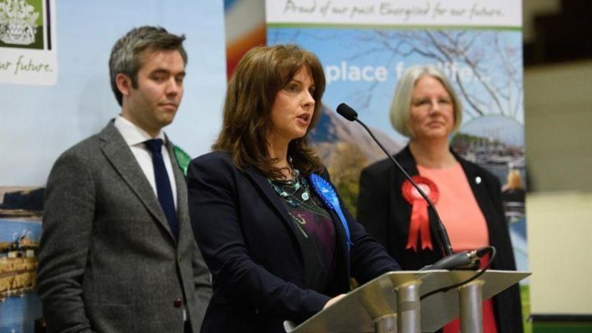 Trudy Harrison (centro) comparece tras su victoria en las elecciones en Copeland, rodeado por el candidato del Partido Verde (izquierda) y la laborista Gillian Troughton, en Whitehaven (Inglaterra), el 24 de febrero.