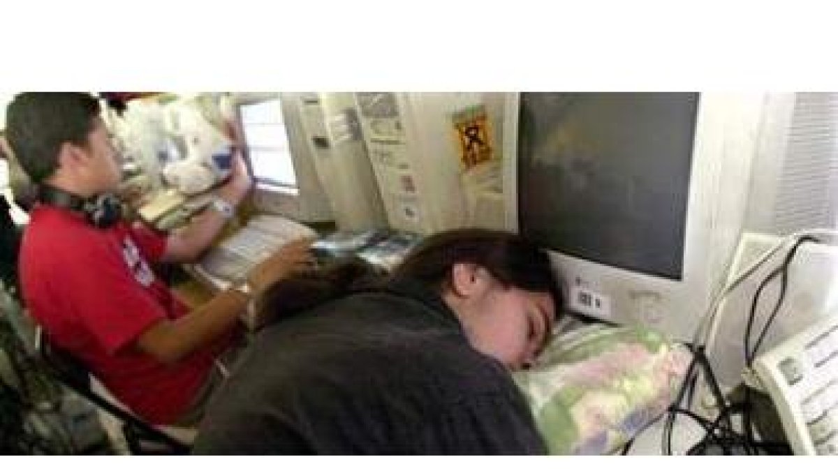 Fotografía de archivo de un jóven dormido ante un ordenador.