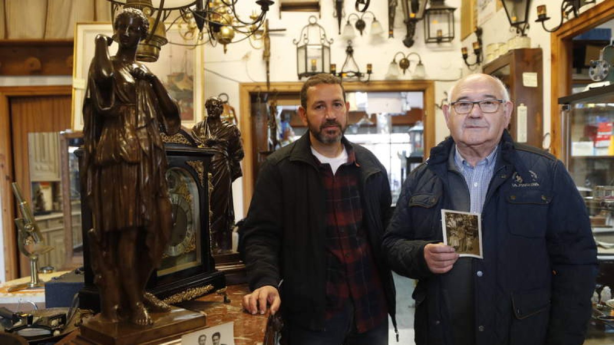 Ángel Sastre posa con su hijo Ángel Carlos, que actualmente está al frente del negocio de Antigüedades Ángel en Boñar. RAMIRO