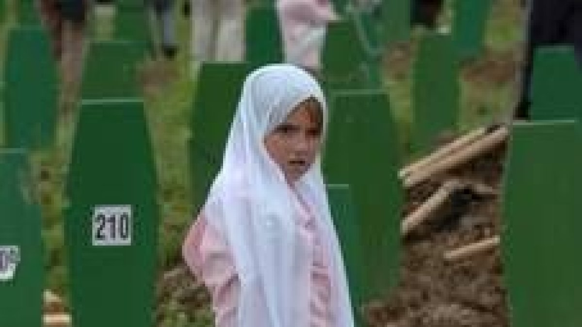 Una niña observa las tumbas de más de seiscientos musulmanes bosnios en los funerales de ayer