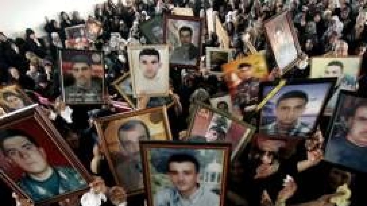Viudas de militantes de Hezbolá muertos durante la guerra muestran sus retratos en Srifa
