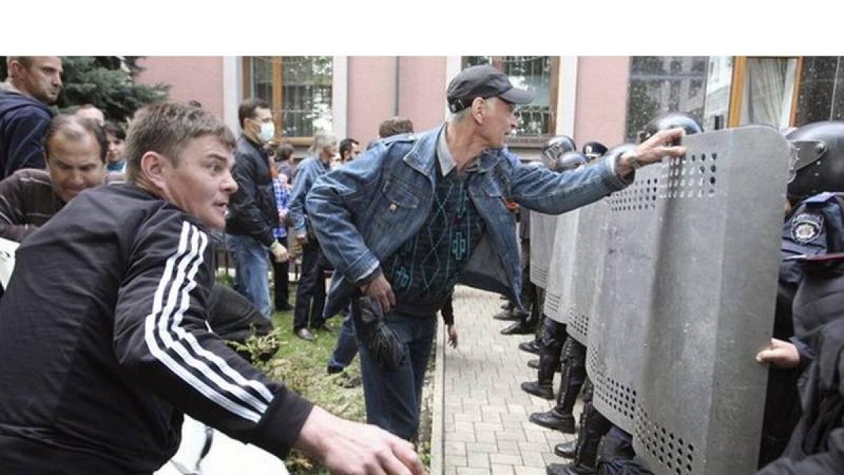 Policías ucranianos intentan repeler el ataque de los manifestantes prorrusos a la Fiscalía regional de Donetsk.