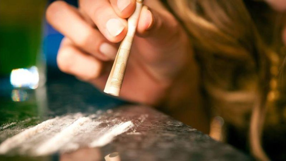 Un consumidor de cocaína esnifa la droga.