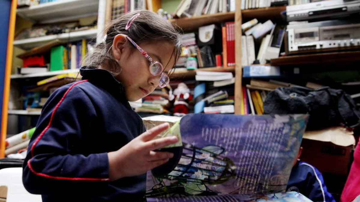 Una niña lee un libro en una biblioteca de Colombia