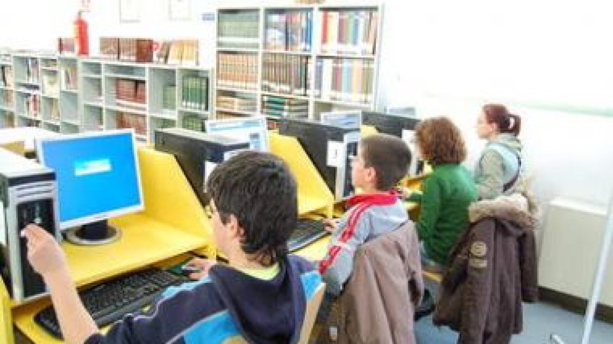 Un grupo de escolares leen en la biblioteca de Trobajo.
