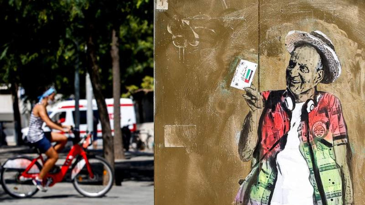 Mural pintado por el artista urbano TV Boy en la Barceloneta. En la foto pequerña, Juan Carlos I saluda a Corinna Larsen. QUIQUE GARCÍA
