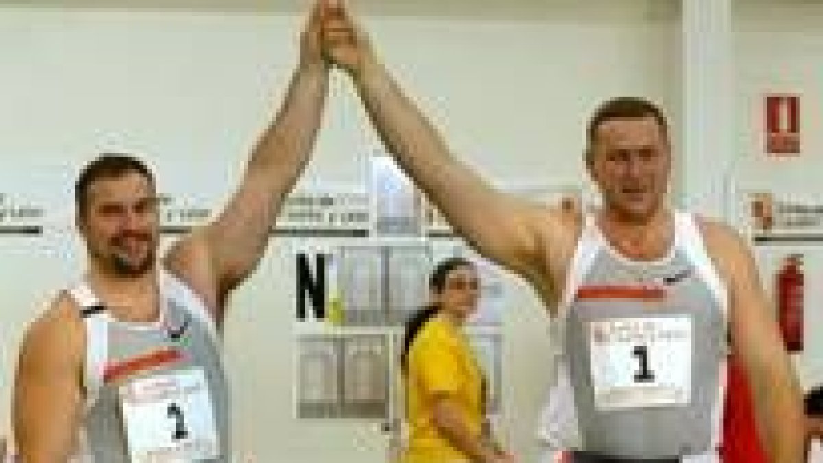 Manuel Martínez y Yuri Bilonog, primer y segundo clasificados en peso, posan tras la prueba