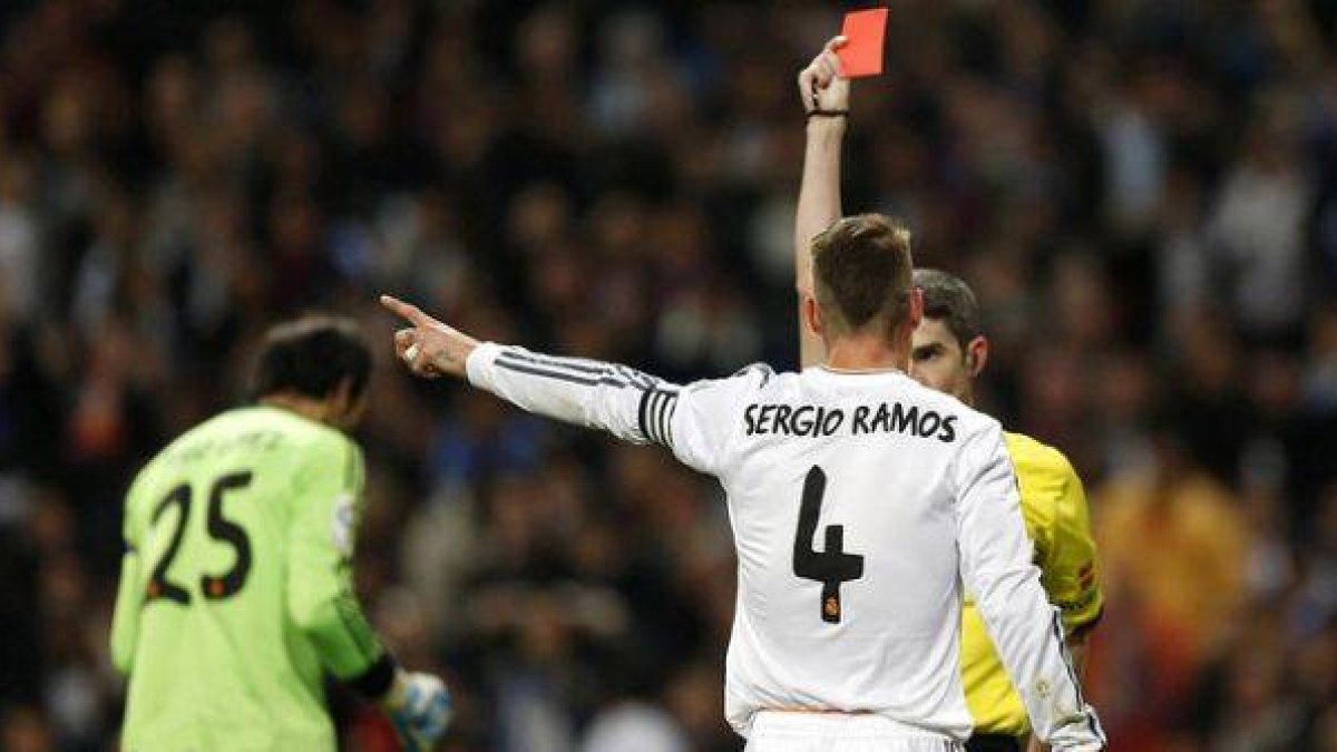 Undiano Mallenco muestra la cartulina roja a Ramos, en un momento del clásico del Bernabéu.