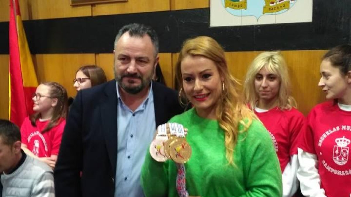El alcalde de Camponaraya, Eduardo Morán, junto a Lydia, que muestra los tres oros obtenidos en el Europeo.