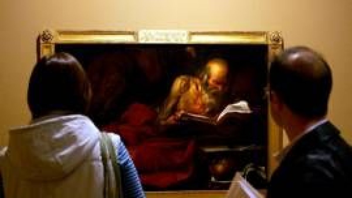 Dos visitantes observan una de las obras expuestas en esta muestra sobre el José de Ribera más joven