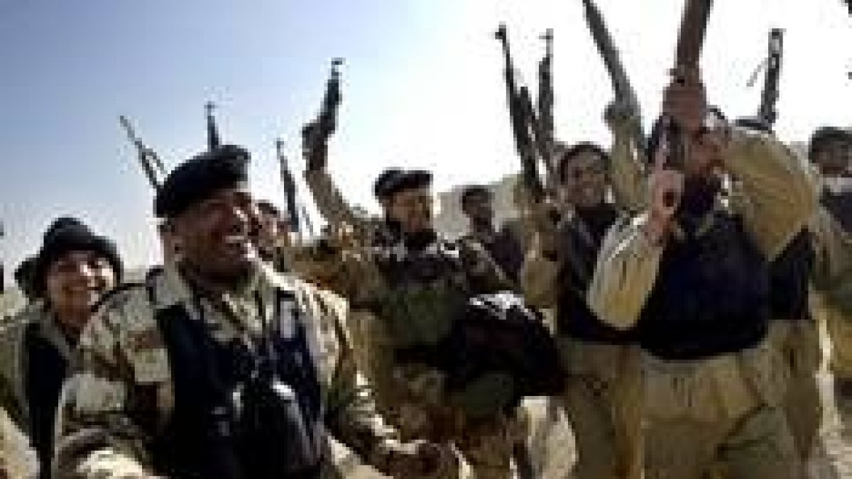 Soldados iraquíes alzan sus fusiles tras la restauración de la seguridad en la frontera de Kusaiba