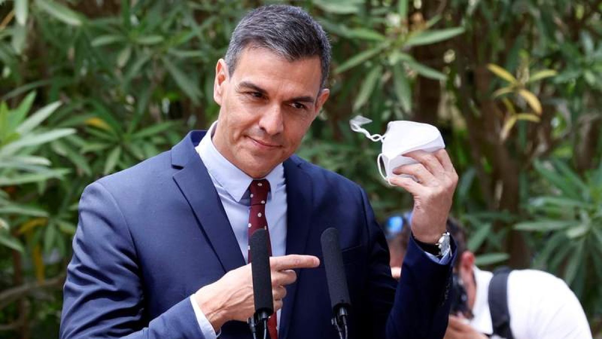 El presidente Pedro Sánchez quitándose la mascarilla para comparecer ante los periodistas en Mallorca. BALLESTEROS