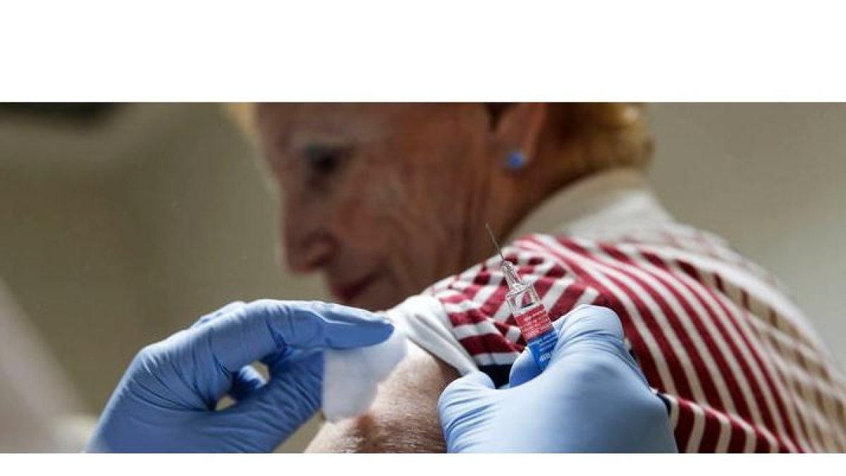 Una mujer recibe una vacuna contra la gripe. MANUEL BRUQUE