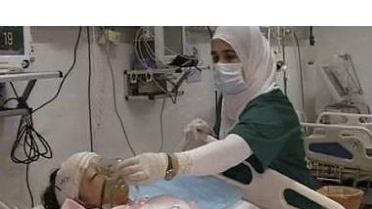 Una enfermera atiende al menor superviviente del accidente de avión en Trípoli.