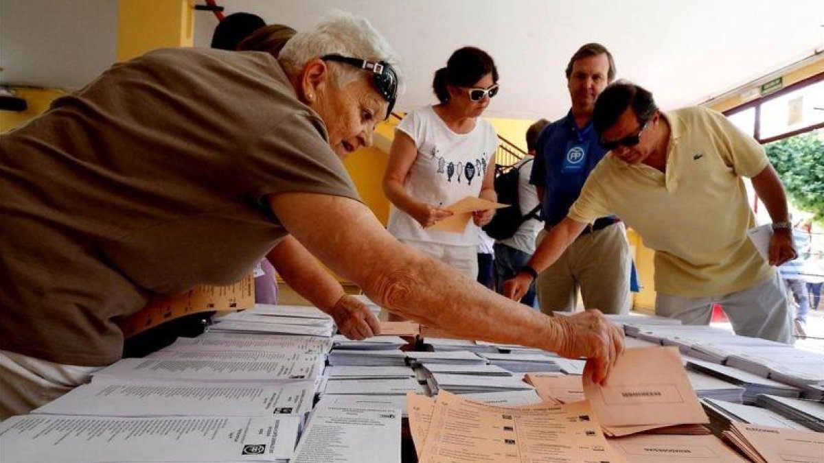 Votantes eligen papeletas en un colegio electoral de Madrid en las elecciones generales del 26 de junio de 2016.