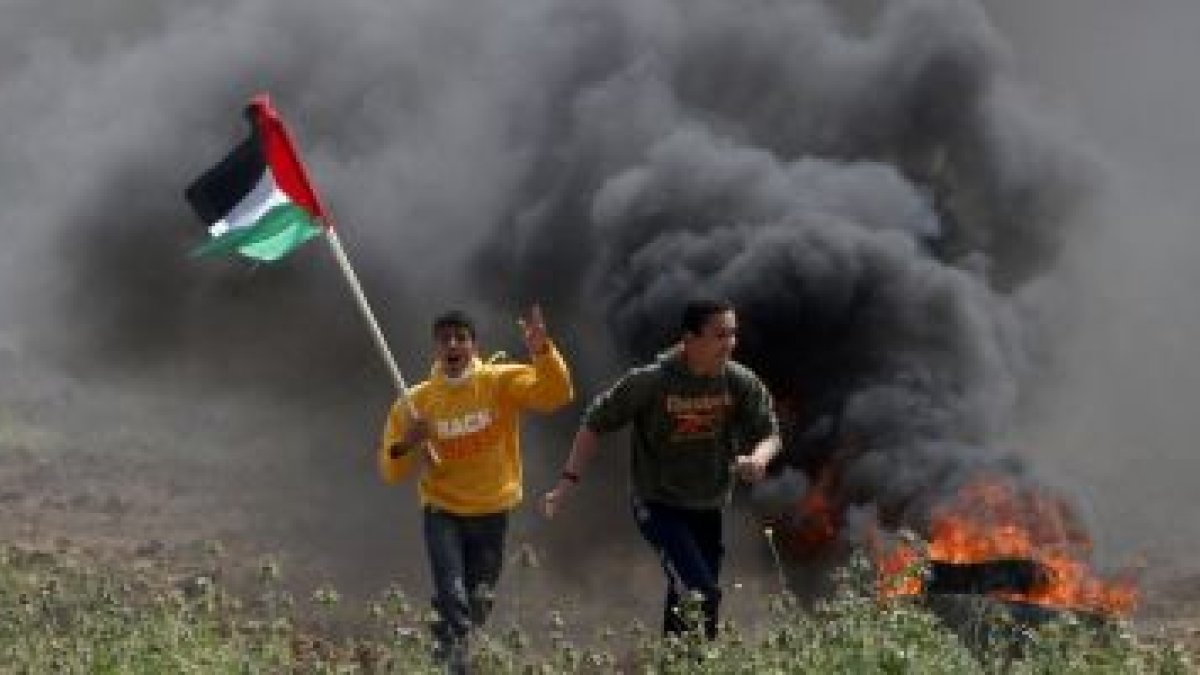 Dos jóvenes palestinos huyen de los soldados israelís cerca de la ciudad de Gaza, ayer.