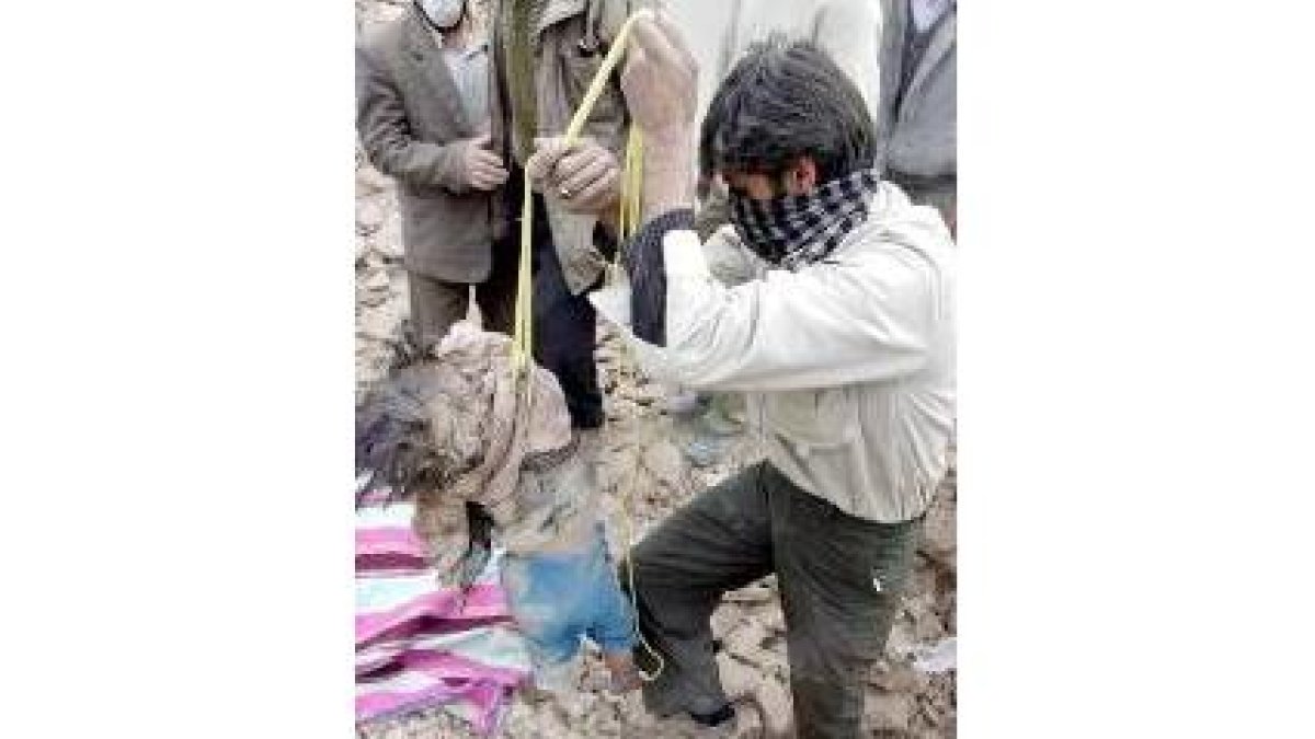 Un iraquí saca el cadáver de un niño de las ruinas de Bam