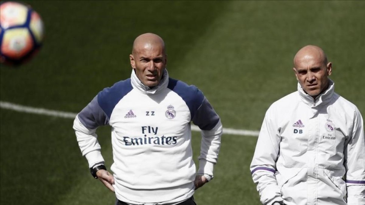 Zinedine Zidane, junto a su ayudante David Bettoni, en el entrenamiento de este sábado en Valdebebas.