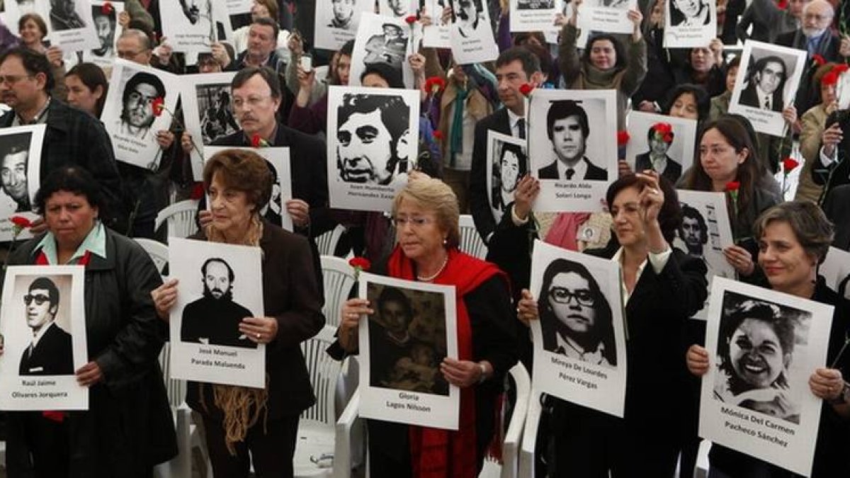 Michelle Bachelet, con chaqueta roja, durante el homenaje a las víctimas de la dictadura, el martes en Santiago.