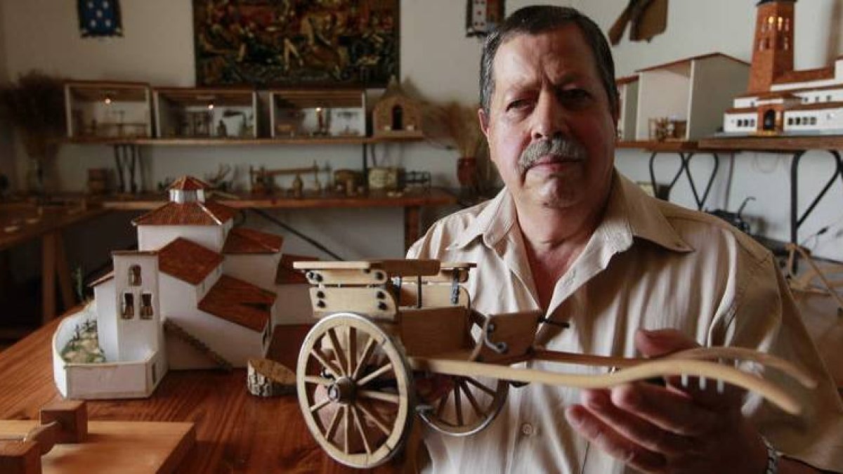 Félix Morán, en el antiguo pajar de su casa, convertido ahora en su museo particular, mostrando un antiguo carro de madera tirado por animales que ha realizado a escala de un original que tenía su padre.