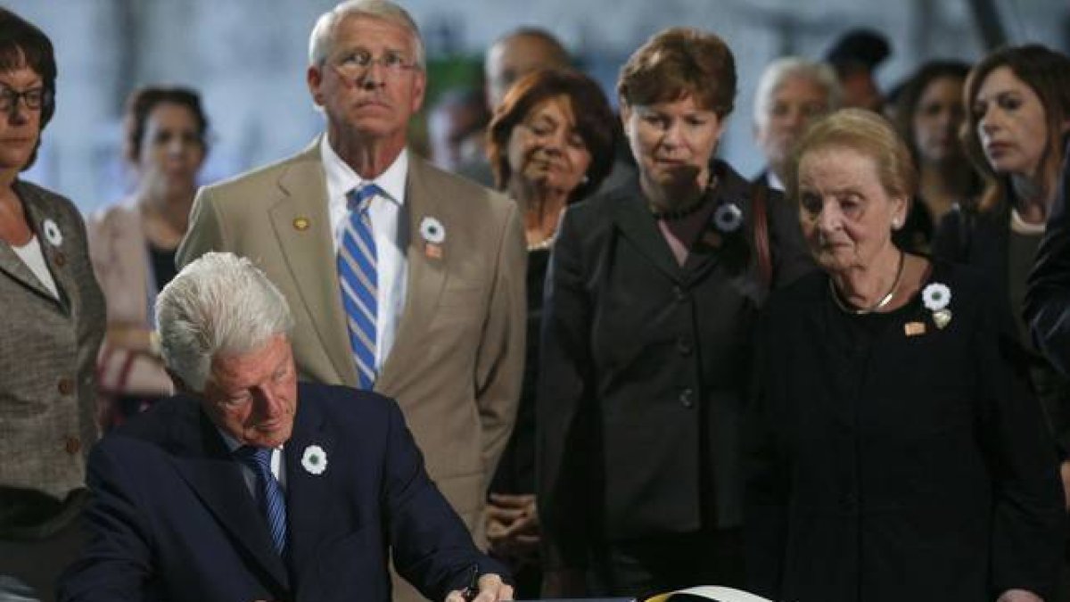 Bill Clinton, expresidente de EEUU, firma en el libro de condolencias ante la mirada de Madeleine Albright, exsecretaria de Estado de Estados Unidos.