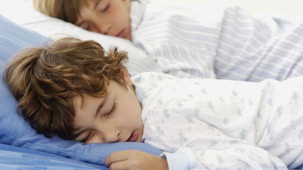 Dos niños en edad escolar durmiendo.