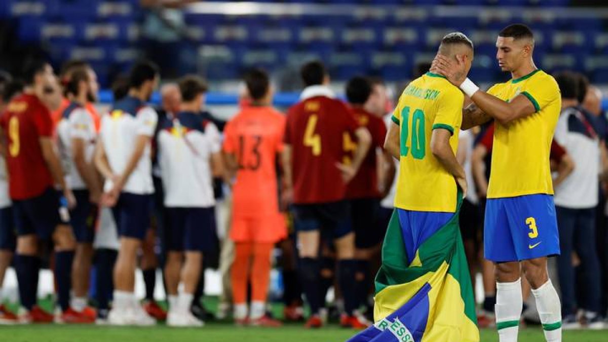 Los jugadores brasileños Richarlison (2d) y Diego Carlos (d) celebran tras vencer a España en la final de fútbol masculino. FERNANDO BIZERRA