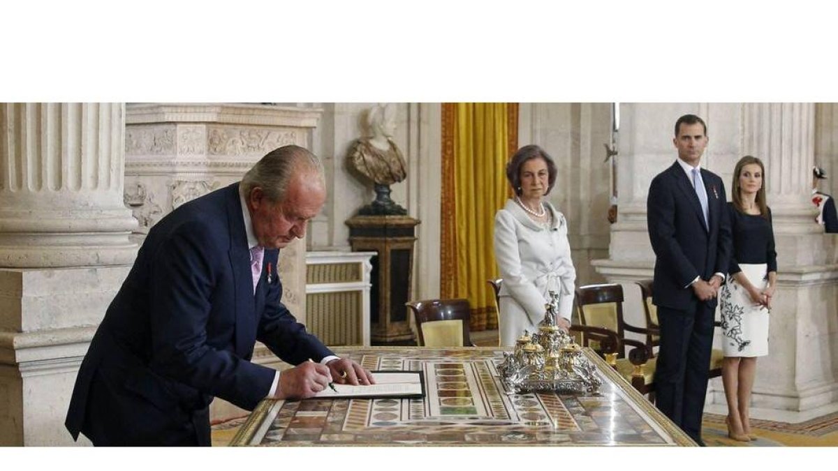 Don Juan Carlos firma su abidicación en presencia de su hijo, doña Sofía y la aún princesa Letizia