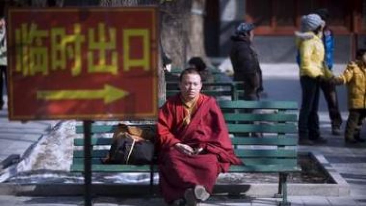 Un monje tibetano descansa en un banco del Templo del Lama en Pekín.