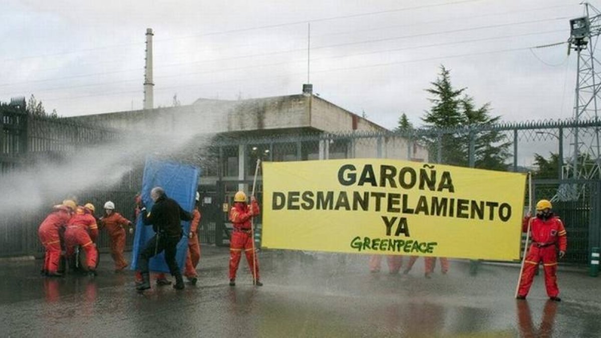 Miembros de Greenpeace, esta mañana, entre los manguerazos empleados para evitar que se acercaran a la central de Garoña.