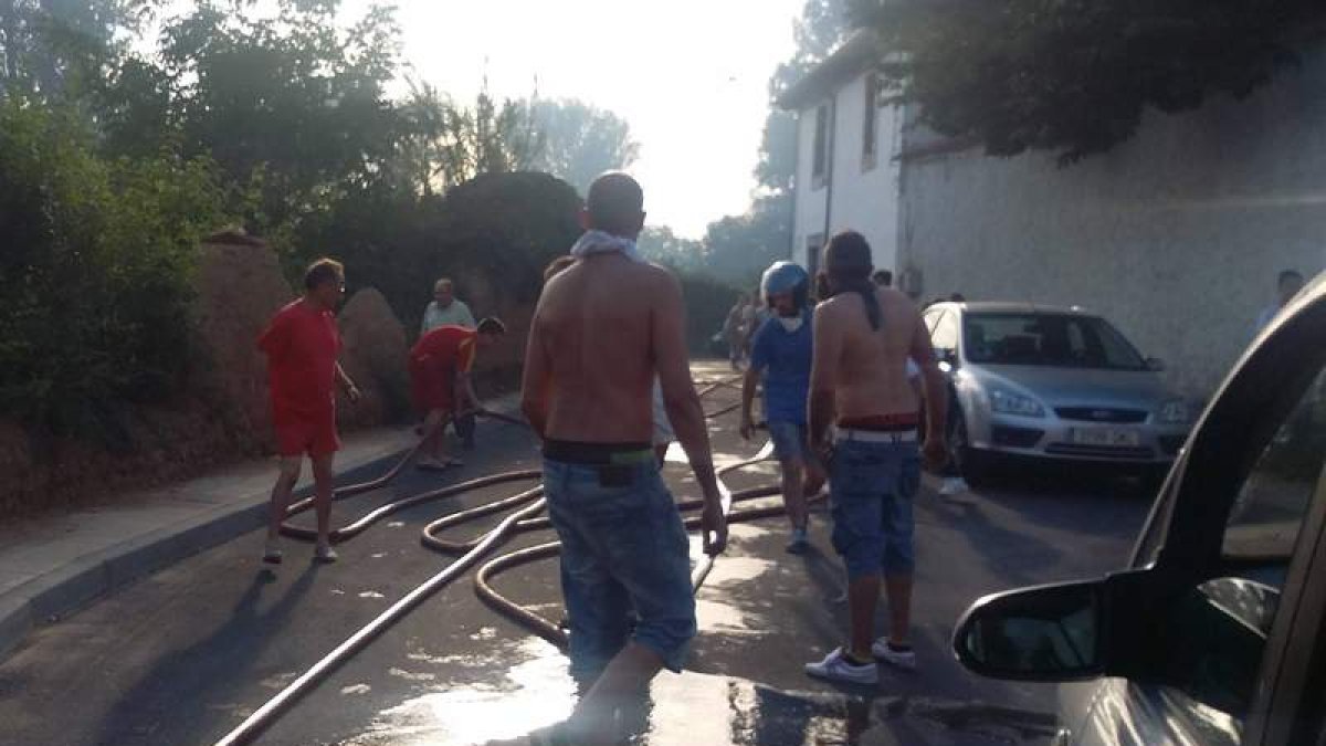Vecinos, durante las labores de extinción del fuego de Santovenia con las mangueras del pueblo.