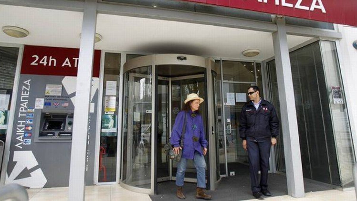 Una mujer sale del banco Laiki, en Nicosia, tras la apertura de las entidades bancarias chipriotas este jueves.