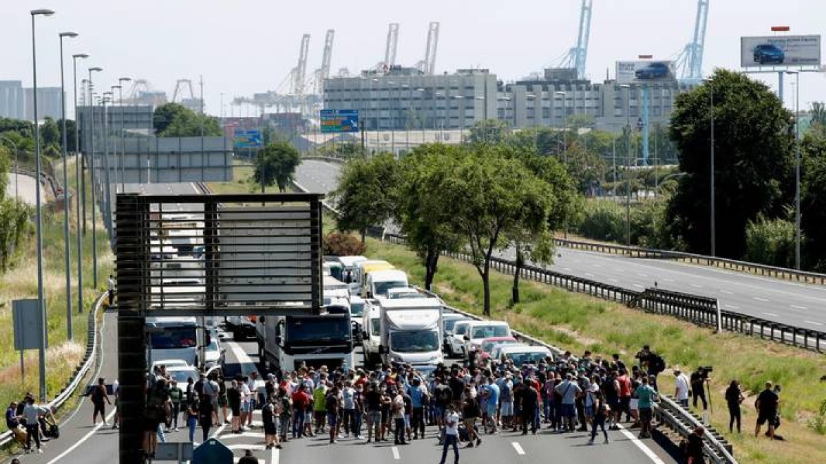 Decenas de trabajadores de la fábrica de Nissan en la Zona Franca cortan el tráfico. ALEJANDRO GARCÍA