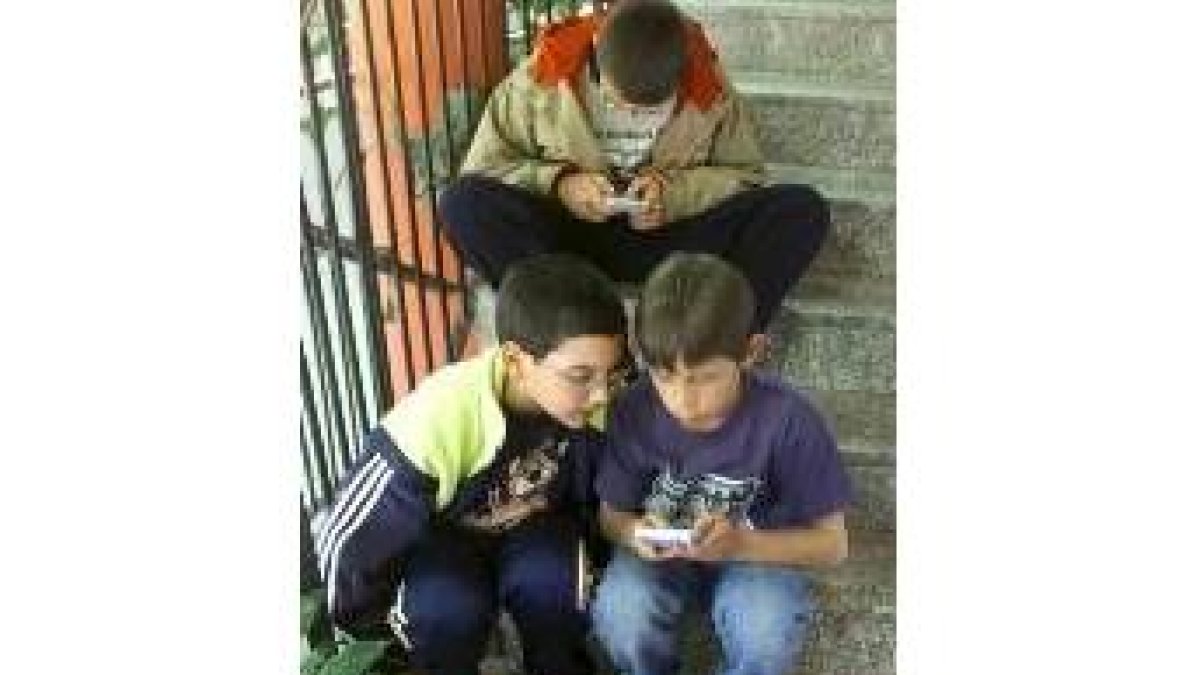 Unos niños juegan a los videojuegos en la calle