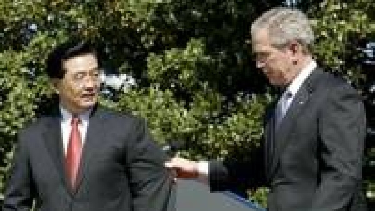 El presidente Hu Jintao observa cómo Bush le tira de la manga de su chaqueta en la Casa Blanca
