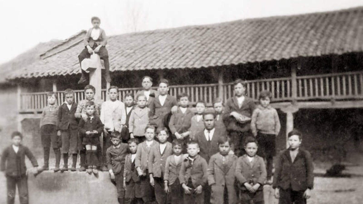 Niños posando con el maestro en la plaza del pueblo de Sueros de Cepeda. Una escena del trabajo en las eras.