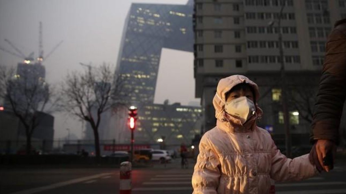 Una niña con una máscara protectora para la contaminación en Pekín, este lunes.
