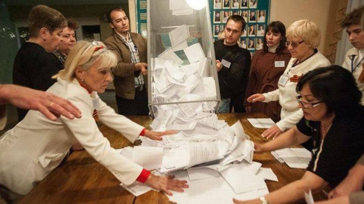 Miembros del comité electoral vacían una urna para hacer el escrutinio tras la votación en Donetsk.