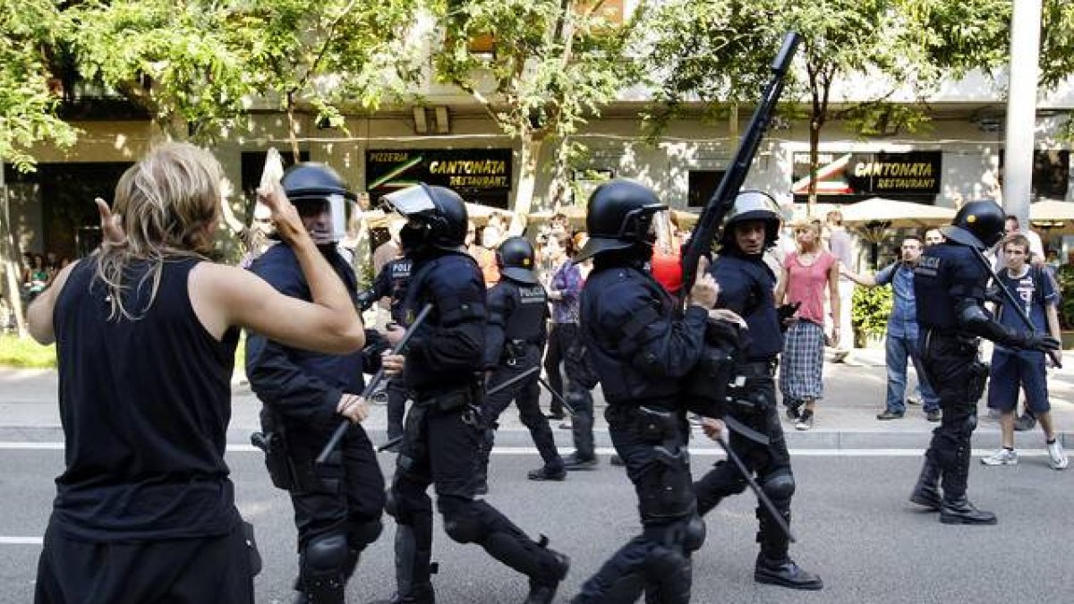 Los mossos intervienen frente a los indignados que quieren frenar el debate sobre los recortes en el Parlament, en junio del 2011