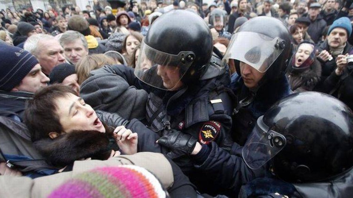 Agentes antidisturbios intentan apresar a un activista rodeados de manifestantes, este lunes en Moscú.